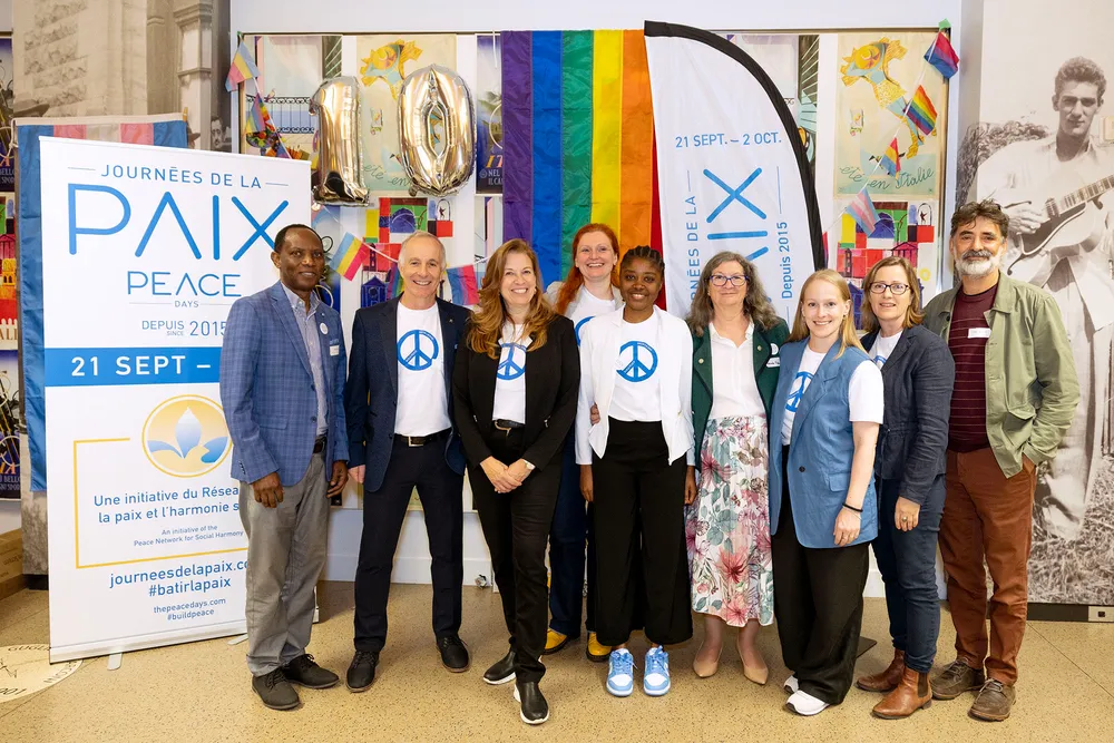 A group at Peace Days Montreal 2024 in front of the Journées de la paix banner